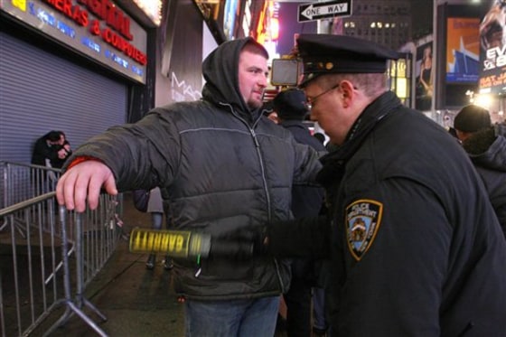 New York City police officer Michael Luciano, right, scans Brandon Caton, from Luray, Va., with a metal detector as he enters the crowd gathering in New York's Times Square to take part in the New Year's Eve festivities on Dec. 31, 2009. In the biggest public party in the country, nearly a million revelers will cram into the streets of Times Square to watch the ball drop on New Year's Eve. The party is also remarkably crime-free, safe and orderly.